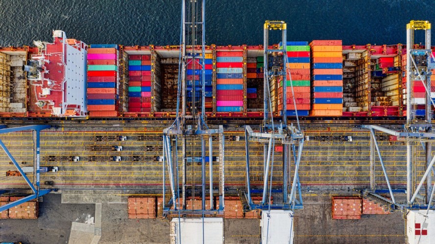 Hafenterminal mitsamt Containerschiff und Umschlagkränen aus der Vogelperspektive