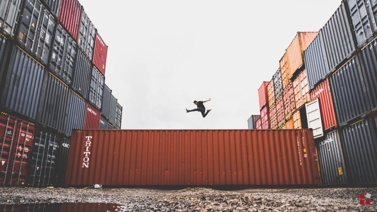 Eine Person springt über einen Container im intermodalen Verkehr
