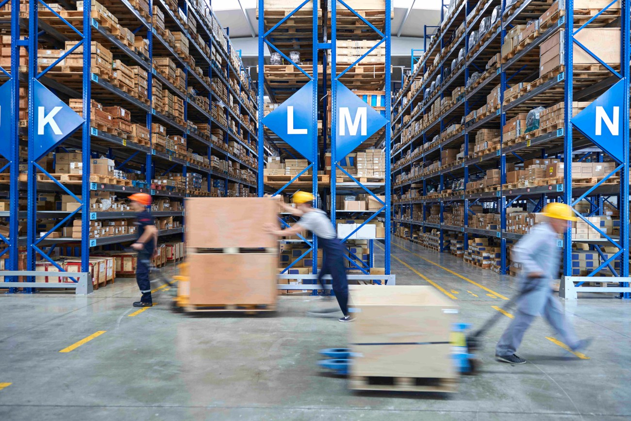 Angestellte in einem Logistiklager bewegen große Güter